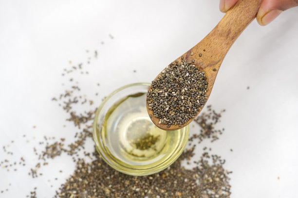 特写照片：木勺中的奇亚籽精油和奇亚籽，这种超级食物富含营养和抗氧化剂。图片下载