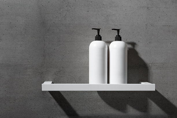 白色货架上的白色瓶子模型，背景为灰色混凝土，特写洗发水、护发素。现代极简浴室中性色调美容产品的审美视角。侧视图，可复制空间。图片下载