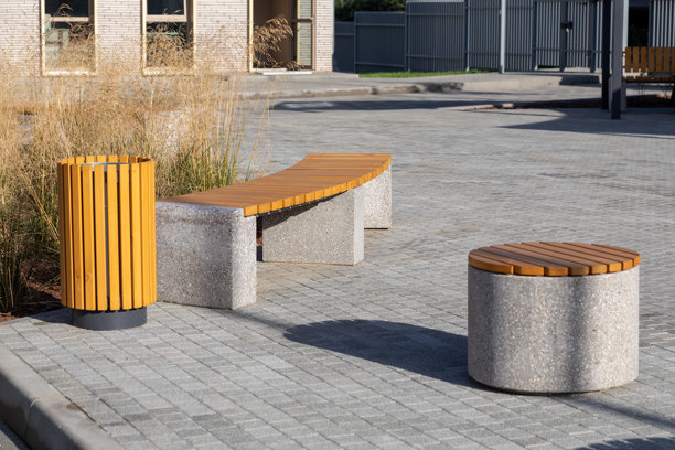 带木质座椅的混凝土长凳。城市休闲区设有混凝土长凳和木质座椅，周围是铺砌的地面，适合建筑可视化。真实照片图片下载