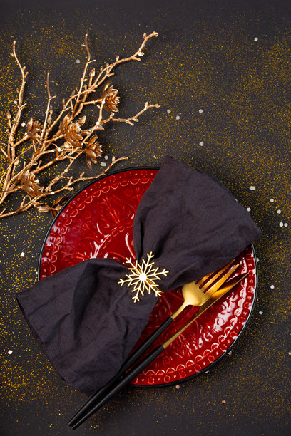 圣诞节庆祝餐桌布置。圣诞餐桌摆设，带有餐巾的空盘子和圣诞装饰品俯视图，竖幅照片图片下载