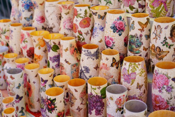 阳光明媚的一天，充满活力的市场摊位上展示着色彩鲜艳的手绘花瓶图片下载