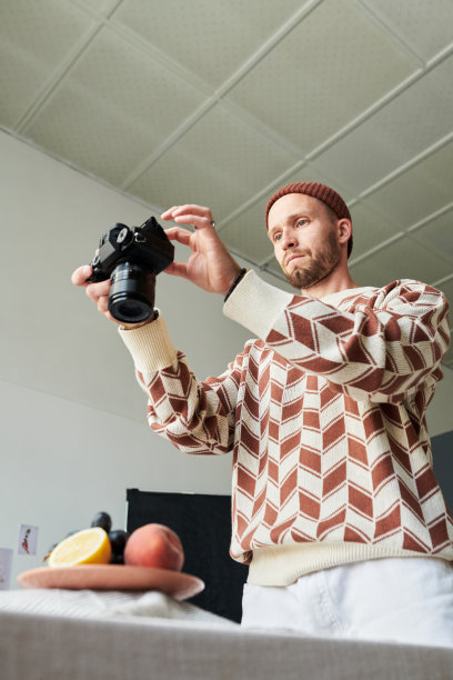 男子在室内拍摄水果拼盘的照片图片下载