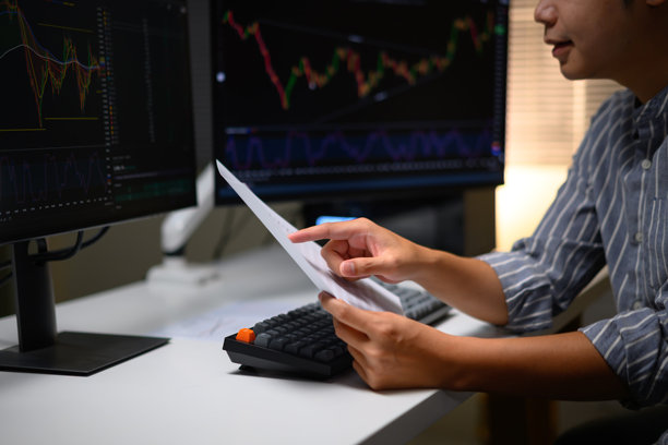 一套特写照片：一位年轻交易员在家中使用电脑分析金融图表，数字市场和股票交易所的未来就业机会图片下载