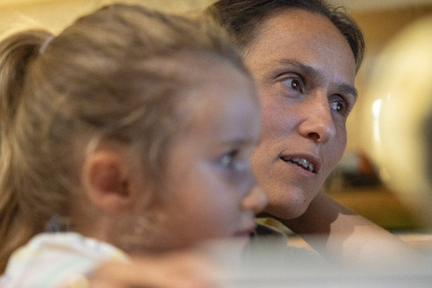 温馨的家庭时光。妈妈和孩子在深夜用笔记本电脑看电视图片下载