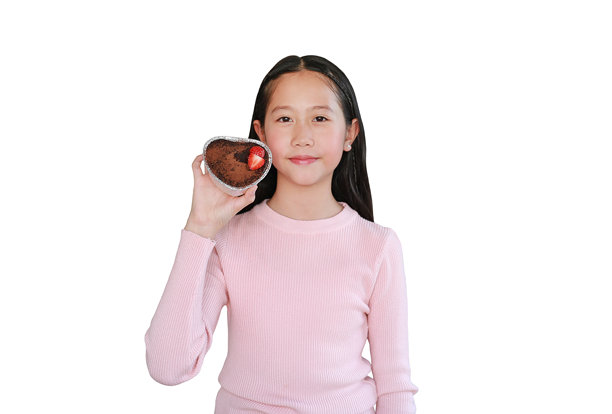 身穿白色上衣的漂亮亚洲女孩，展示着上面有草莓的巧克力蛋糕，背景为白色。图片包含剪切路径。图片下载