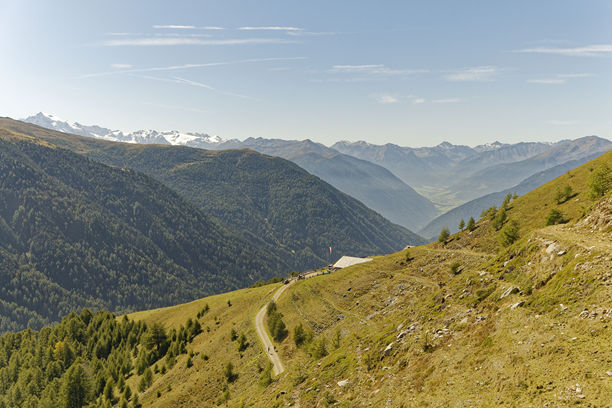 广阔的山地景观，前景是陡峭的山坡草甸，背景是荒野的山脉。图片下载