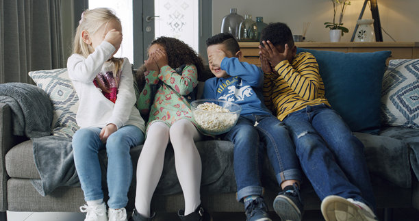 爆米花，孩子们在客厅的沙发上一起看电视，害怕地遮住眼睛，吃着爆米花，朋友们聚在公寓里看恐怖电影，享受亲子时光。图片下载