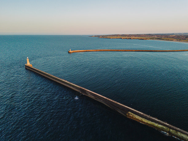 日落时分，暮色笼罩下的泰尼茅斯码头沐浴在北海温暖的余晖中。航拍无人机照片图片下载