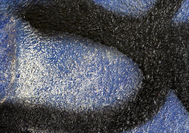 城市街头艺术的极端特写。这张宏观抽象图片展示了粗糙混凝土墙上喷漆的纹理，营造出强烈的颓废背景。图片下载