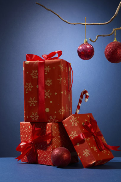 圣诞礼物堆，配有装饰球和丝带。垂直构图，丰富的红色调，适合节日产品或包装图片。图片下载