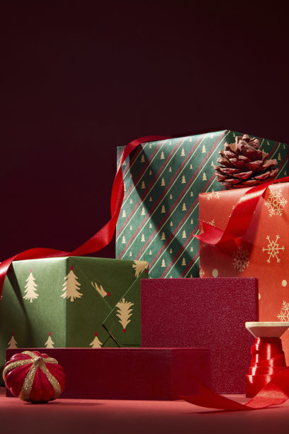 红色和绿色的包装礼盒堆叠着节日丝带。温馨的圣诞构图，柔和的光线和节日魅力。圣诞节的广告照片图片下载