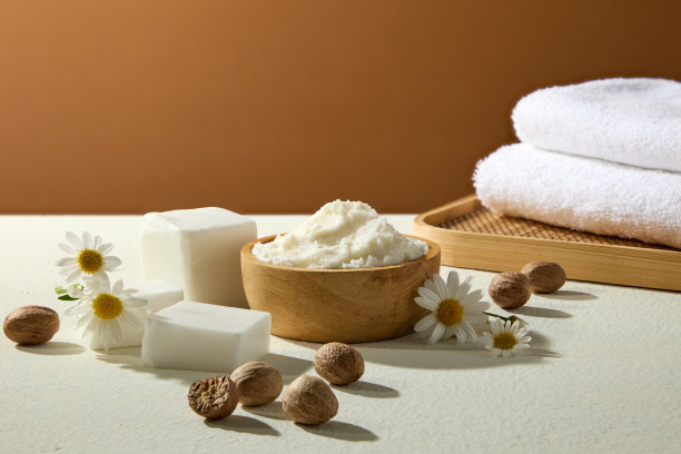 未加工乳木果油和坚果的静物，搭配白色毛巾和洋甘菊，为护肤和水疗产品广告概念进行摆拍。图片下载