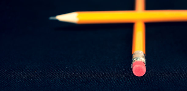 带有红色橡皮擦的黄色石墨铅笔，孤立在深色背景上，用于广告和在线商店的专业文具产品照片图片下载