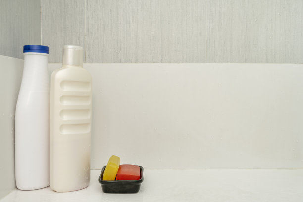 淋浴间内放有洗发水瓶子和色彩鲜艳的甘油皂，旁边还有一个白色的皂碟图片下载