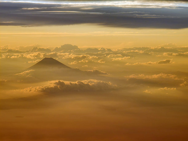 从飞机上拍摄日本富士山的照片。富士山在夕阳和云海中尤为美丽。从飞机上俯瞰地面的景色。图片下载