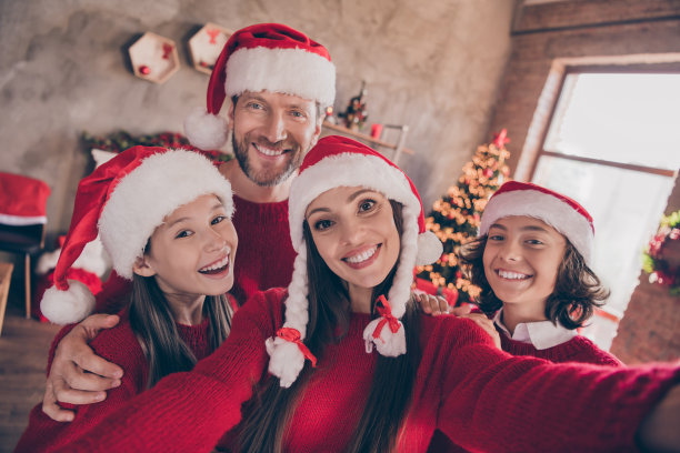 照片：时髦迷人的兄妹/夫妻在室内房间/家中录制圣诞视频，微笑着表示祝贺图片下载