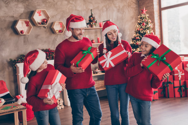 照片：洋溢着快乐的家庭在装饰过的圣诞家居室内，接收特别的快递礼物盒，猜测着里面的惊喜图片下载