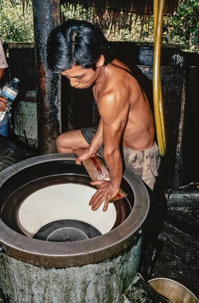 越南西贡糖厂工人于1992年10月1日在离心机中处理新鲜提取的甘蔗糖的历史彩色照片图片下载