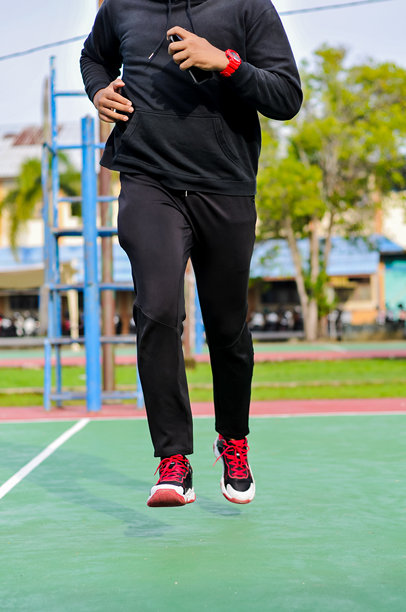 一名快乐的络腮胡男子在绿色运动场上户外奔跑进行健身训练的全身动态照片图片下载