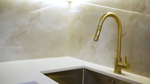 金色的厨房水龙头和白色台面图片下载