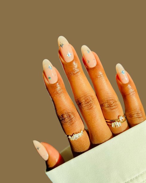 一位拥有光滑棕色皮肤的年轻女性的手，展示着优雅的现代美甲和创意手绘美甲设计图片下载