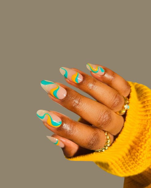 年轻女性光滑的棕色皮肤的手，展示着优雅的现代美甲和创意手绘指甲艺术设计图片下载