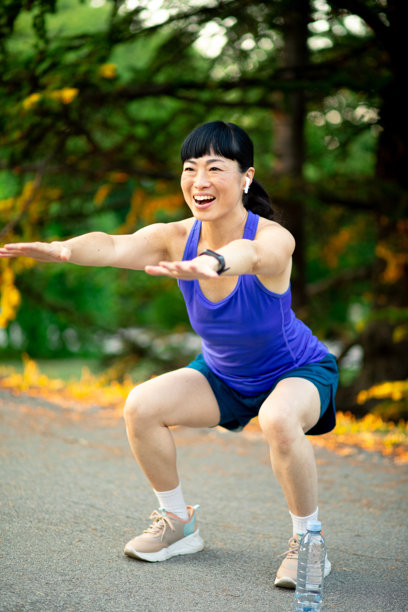 亚洲女性在公园锻炼深蹲的素材图片图片下载