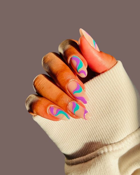 肤色光滑的棕色皮肤的年轻女性的手，展示着优雅的现代美甲和创意手绘美甲设计图片下载