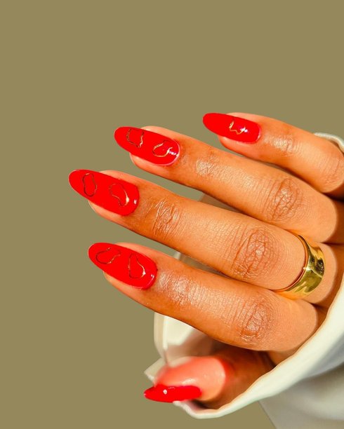 年轻女性的双手，拥有光滑的棕色皮肤，展示着精致的现代美甲和创意手绘美甲设计图片下载