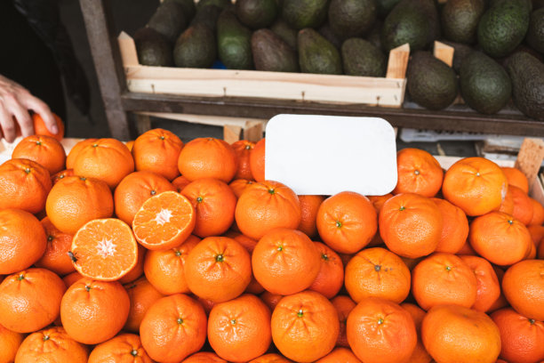 水果市场摊位上堆放着新鲜橙子。这张图片表达了自然丰饶、维生素能量和健康日常营养的理念。图片下载