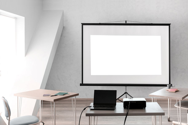 照片显示的是一个会议或培训室的布置，明亮现代的办公空间里的小桌子上摆放着投影屏幕、笔记本电脑和数字投影仪。图片下载