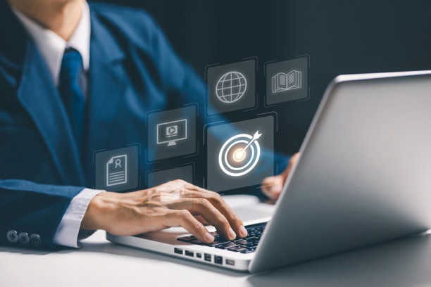 一名商务人士正在使用笔记本电脑，屏幕上漂浮着目标和成功的全息图标，象征着目标达成、战略规划、商业目标和数字营销的成功。图片下载