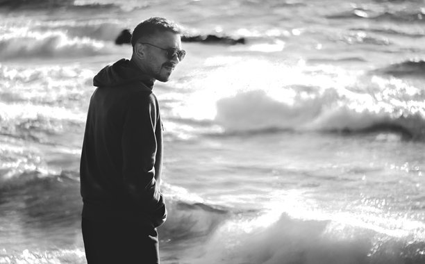 一位年轻男子在海边的黑白照片图片下载