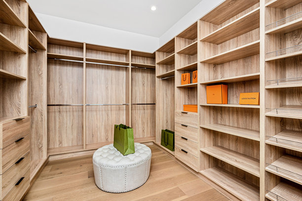 现代步入式衣帽间与奢侈品牌包包和白色脚凳图片下载