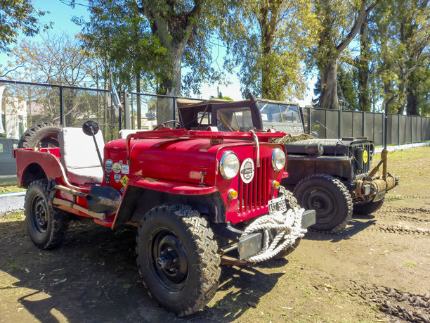 一辆老式橙色IKA吉普车，配有大型越野轮胎，基于威利斯CJ车型，停在公园的经典汽车展上图片下载