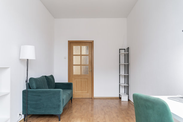 客厅里舒适的氛围。绿色的沙发被落地灯照亮。房间里有沙发、窗帘和灯。沙发上放着柔软的靠垫。是放松和享受宁静时刻的空间。由灯光照亮。图片下载