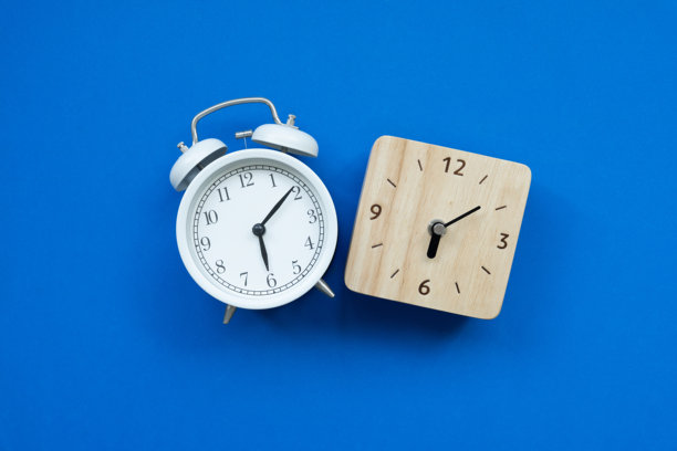 复古闹钟，置于蓝色桌子背景上，复古风格，平面图片下载