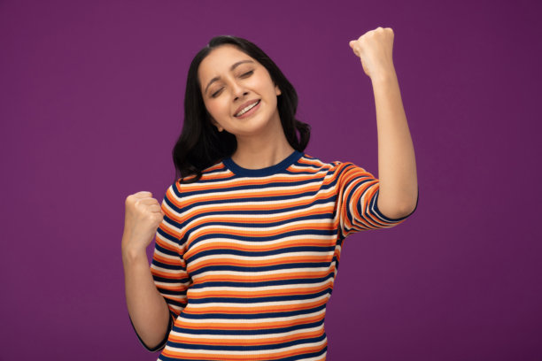 身穿条纹T恤的漂亮年轻女孩，孤立在紫色背景上的照片素材图片下载