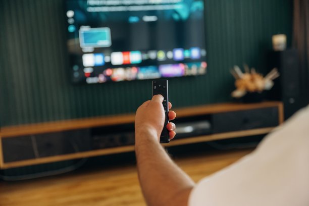 男人手持电视遥控器，坐着享受空闲时光的特写照片图片下载