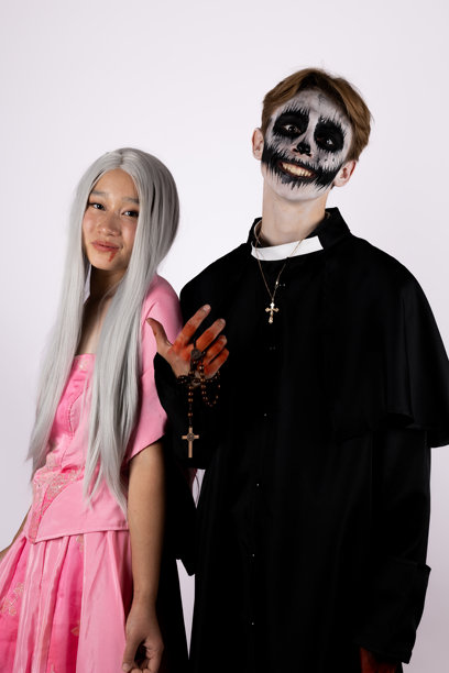 模特们正在为万圣节主题照片摆姿势，其中一人穿着可怕的服装。图片下载