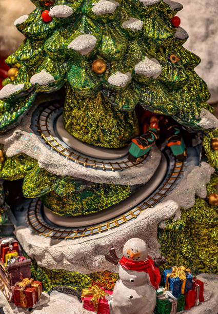节日圣诞树，带有旋转的火车轨道、雪人、彩色礼物和雪景细节。用于假日广告和设计的素材照片图片下载