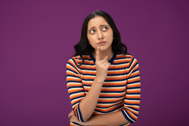 穿着条纹T恤的漂亮年轻女孩照片，背景为紫色孤立图片下载