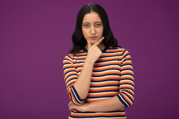 身穿条纹T恤的美丽年轻女孩，孤立在紫色背景上的照片素材图片下载