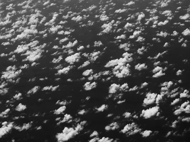 从上方视角拍摄的，海洋上空大片热带浅积云的黑白照片图片下载