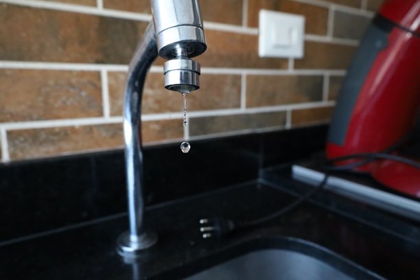 浴室洗脸盆金属水龙头上的水滴特写图片下载