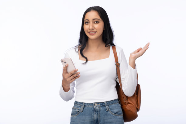 印度年轻女学生，背着包，使用手机，在白色背景下孤立的素材照片图片下载