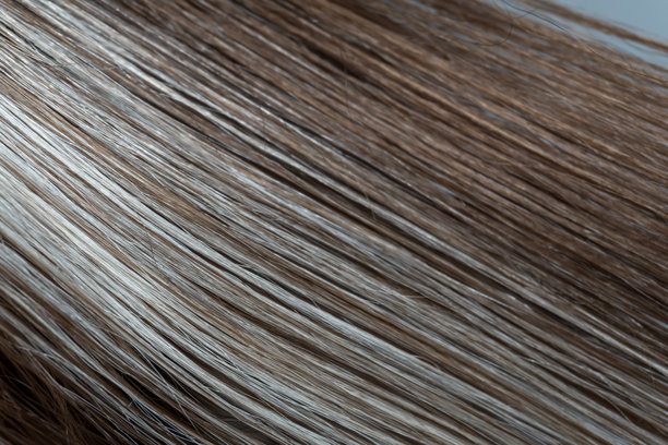 特写照片，捕捉到互相平行的灰色和棕色发丝的笔直纹理和对比度。图片下载