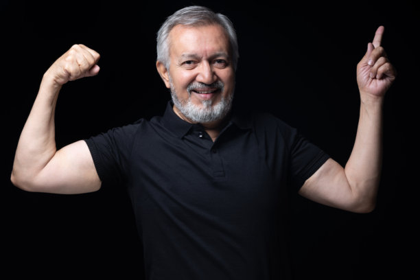 照片：一位穿着黑色T恤的老年男子，在黑色背景上隔离，素材照片图片下载