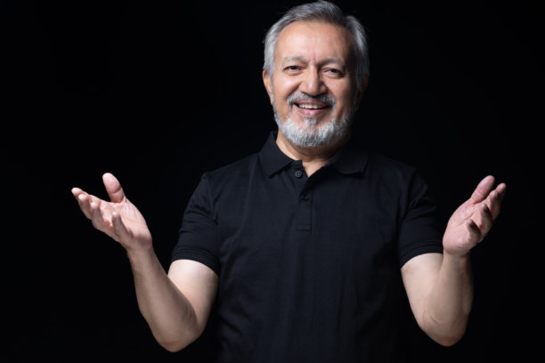 身穿黑色T恤的老年男性，黑色背景下的照片素材图片下载