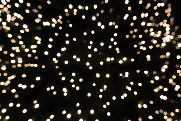 绚丽的抽象金色散景背景照片，明亮的圆形光晕映衬着漆黑的夜晚，非常适合节日庆典和假日设计的叠加。图片下载